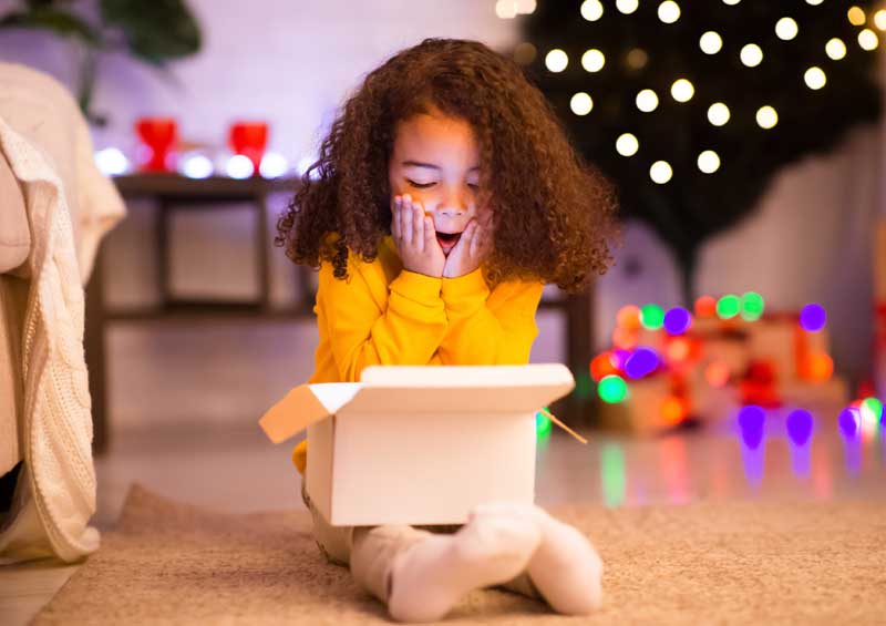 child opening present on Christmas morning