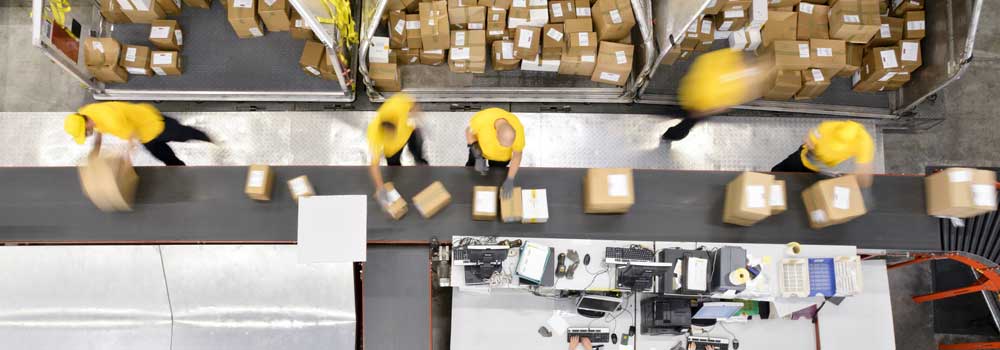 distribution centre staff working at a conveyor belt with parcels