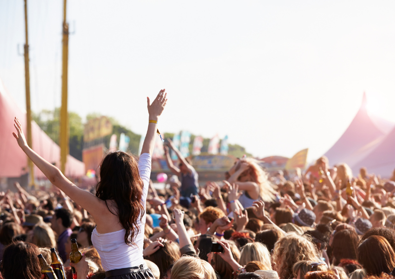 Festival goers enjoy an outdoor music festival in the sunshine