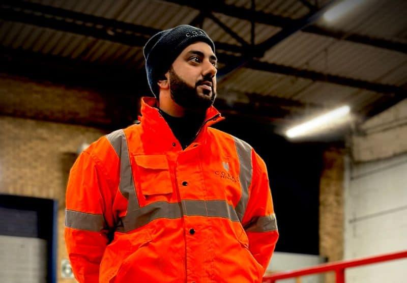 Cobac Security officer in orange high vis jacket on duty at a distribution centre at night